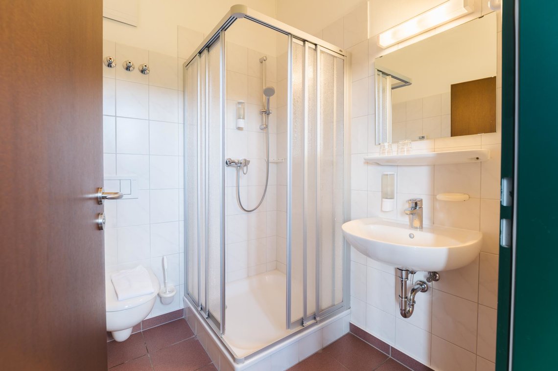 Ein Badezimmer mit Toilette, Dusche und Waschbecken