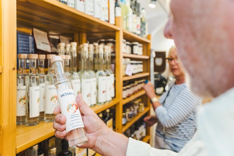 Ein Mann hält eine Flasche "Huysburger Apfel-Boskop Edelobstdestillat 0,2l 40% vol."